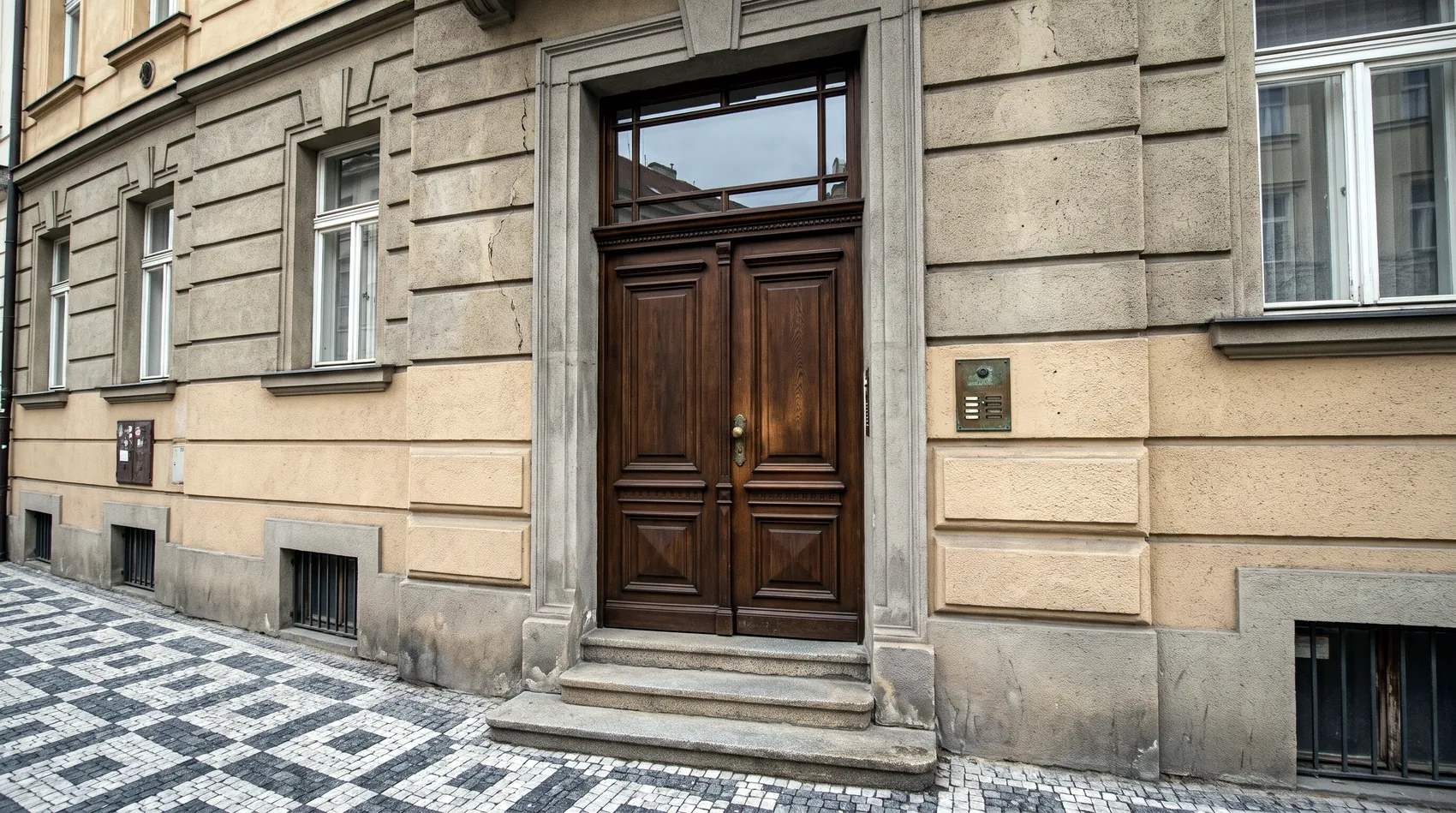 Dvoukřídlé dřevěné vchodové dveře bytového domu s proskleným nadsvětlíkem